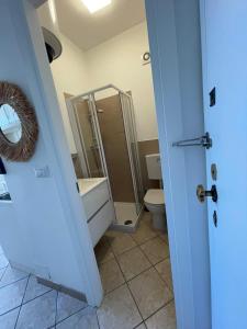 a bathroom with a toilet and a sink and a mirror at Cinquantanove al mare in San Bartolomeo al Mare +4 photos