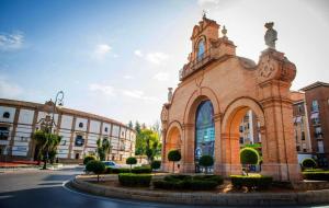 a large brick building with a clock tower on a street at Apartment Dolmen de Menga in Antequera
