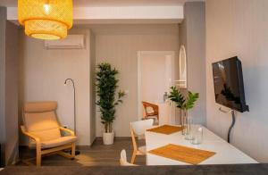 a living room with a tv and a table and a chair at Apartment Dolmen de Menga in Antequera