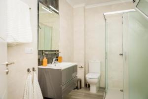 a bathroom with a sink and a toilet and a shower at Apartment Dolmen de Menga in Antequera +5 photos