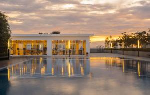 a building with a pool of water in front of it at The Red Room Alanis Residence in Sepang