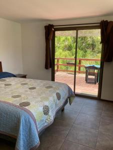a bedroom with a bed and a sliding glass door at Cottages by the river in Rivadavia