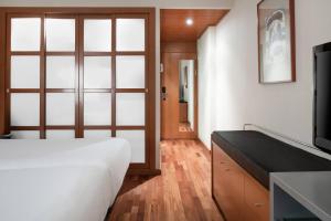 Un dormitorio con una cama blanca y un televisor. en AC Hotel A Coruña by Marriott, en A Coruña 41 fotos más