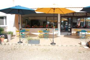 a patio with tables and chairs and umbrellas at Gîte le pont de la Loire in Bourbon-Lancy