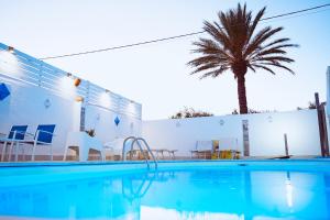 a swimming pool with a palm tree in the background at Residence Nonna Mariuccia in Mazara del Vallo