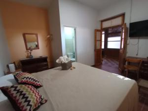 a bedroom with a large white bed and a television at Habitación en Ciudad con baño privado en suite y cochera in La Cieneguita