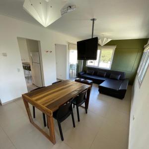 un soggiorno con un tavolo di legno e un divano di NovaVista Apart & Spa a Villa Gesell