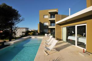 un gruppo di sedie sedute accanto a una piscina di NovaVista Apart & Spa a Villa Gesell