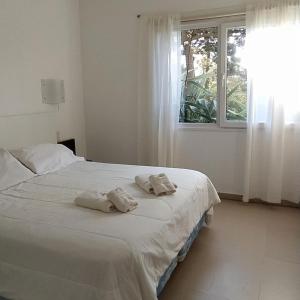una camera da letto con un letto con asciugamani sopra di NovaVista Apart & Spa a Villa Gesell