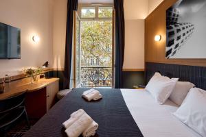 a hotel room with a bed and a window at 6 VH Hotel in Paris