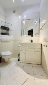 a bathroom with a sink and a toilet and a mirror at Apartament Metro Natolin in Warsaw