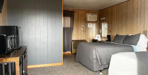 una habitación de hotel con una cama y un televisor en Sportsmen Motel, en Jordan
