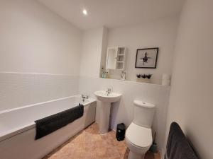a bathroom with a sink and a toilet and a bath tub at Catchpole Stays Abbey Field Apartment- A lovely 2 bed apartment with field views near Colchester town centre in Colchester +67 photos