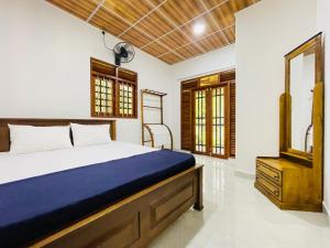 a bedroom with a large bed and a mirror at Paradise Villa in Weligama