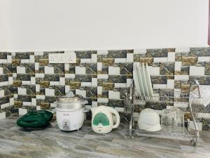 a kitchen with a tiled wall and some appliances at Paradise Villa in Weligama
