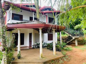 a white house with a staircase in front of it at Paradise Villa in Weligama