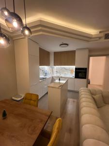 a kitchen and living room with a table and a couch at Amelie's Apartment 2 in Skopje