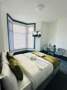 a bedroom with a large bed with a flat screen tv at The New Valron Hotel in Blackpool