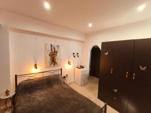 a bedroom with a bed and a dresser at Relaxrooms, 1 queen size bed, swimming pool in Agios Georgios