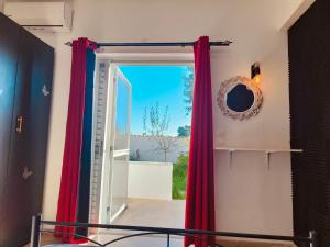 a doorway with red curtains and a mirror at Relaxrooms, 1 queen size bed, swimming pool in Agios Georgios