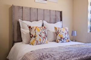 a bedroom with a large bed with pillows at Ridge Comfort in Midrand +22 photos