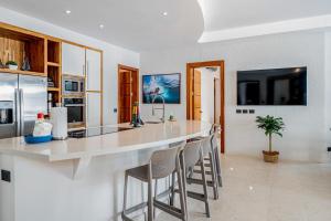 eine Küche mit einer großen weißen Theke mit Stühlen in der Unterkunft Hermosa Waves A1 in Playa Hermosa