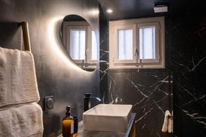 un bagno con lavandino e specchio di Le Boudoir Secret - Love Room avec Chambre Secrète a Le Luc