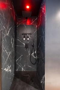bagno con doccia e pareti in marmo nero di Le Boudoir Secret - Love Room avec Chambre Secrète a Le Luc