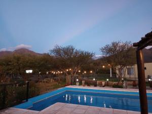 a swimming pool at night with mountains in the background at Solares de Capilla in Capilla del Monte