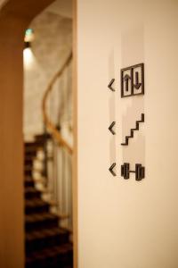 a hallway with a stairway with arrows on a wall at 6 VH Hotel in Paris