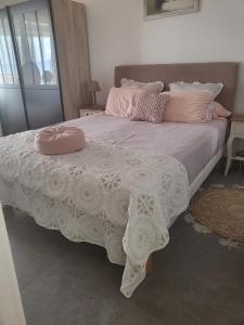 a large bed with pink pillows on top of it at Appartement T2 vue sur les sanguinaires in Ajaccio