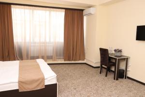a hotel room with a bed and a desk and a window at Yerevan Centre Hotel in Yerevan