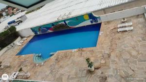 a swimming pool with a painting on the side of a building at Loft vistamar business completo in Macaé