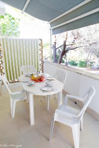 a white table and chairs sitting on a porch at Hotiday Apartments Case Bianche in Orosei