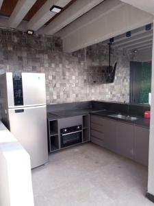 a kitchen with a white refrigerator and a sink at 604- Suíte da Diretoria- Lua de Mel- varanda vista mar- 5 min praia in João Pessoa