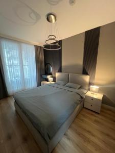 a bedroom with a large bed and a chandelier at Amelie's Apartment 1 in Skopje +12 photos