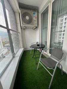a balcony with a table and chairs and a fan at Amelie's Apartment 1 in Skopje