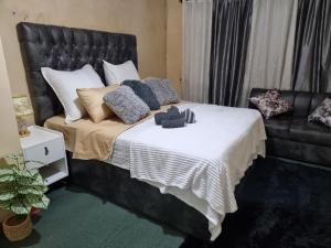 Un dormitorio con una cama con un osito de peluche encima. en The Leafy Haven, en Harare