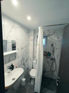a bathroom with a white toilet and a sink at Relaxrooms, 1 queen size bed, swimming pool in Agios Georgios +11 photos