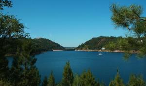 un gran lago azul con árboles en la orilla en Casa do Retiro, en Pedrógão Grande