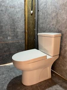a white toilet sitting in a room at Buena Onda Surf House in León