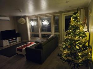 a living room with a christmas tree and a couch at Villa Pare in Rovaniemi