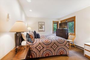 a bedroom with a bed and a desk with a lamp at Highridge A16 Stunning Three Bedroom Condo with Whirlpool Bath, Heated Pool, and Game Room in Killington +37 photos