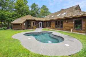 a house with a small pool in the yard at Highridge A16 Stunning Three Bedroom Condo with Whirlpool Bath, Heated Pool, and Game Room in Killington