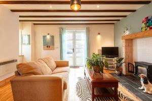 a living room with a couch and a fireplace at Cute cottage for short getaway in Cross Mahon