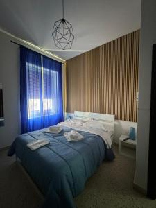 a bedroom with a bed with blue sheets and a window at Rooms hub Portarotese in Salerno