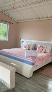 a bedroom with a large bed in a room at Alojamiento en Lago Calima, chalets de montaña con piscina y jacuzzi in Yotoco
