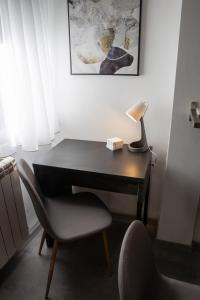 a desk with a lamp and a chair in a room at Studio Piaf City Break Nest in Belgrade +3 photos