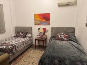 a bedroom with two beds and a table and a painting at Villa dream in Sheikh Zayed