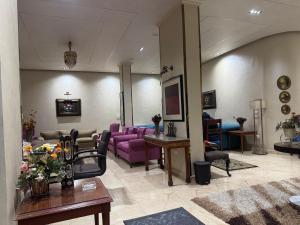 a living room with purple chairs and a couch at Villa dream in Sheikh Zayed